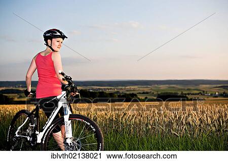 Female cyclist in rural landscape View Large Photo Image Stock Image - Female cyclist in rural landscape. Fotosearch