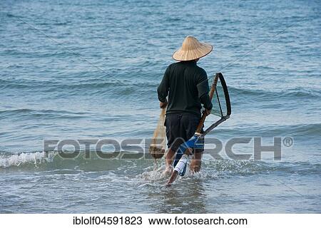 Fisherman wearing a straw hat, Cua Dai beach in Hoi An, Vietnam, Asia View Large Photo Image Stock Image - Fisherman wearing a straw hat, Cua Dai beach in Hoi An, Vietnam, Asia. Fotosearch