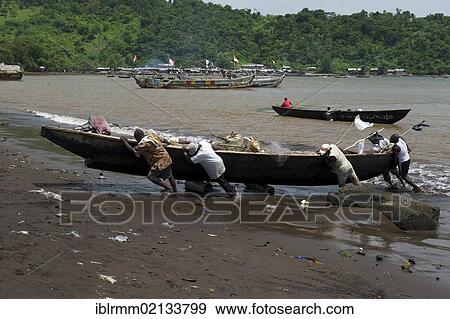 Stock Photo - Fishermen pulling a boat ashore, Limbe, Cameroon, Africa. Fotosearch