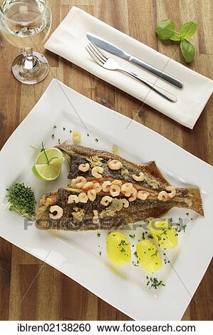 Stock Image - Fresh Plaice (Pleuronectes platessa), Buesum style with shrimps and boiled potatoes. Fotosearch