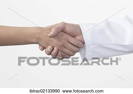 Stock Image - Hands shaking, handshake between patient and doctor. Fotosearch