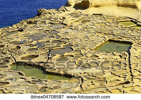 Stock Photo - Hiker at Gozo Salt Pans, Xwejni Bay, Gozo Island, Malta, Europe. Fotosearch