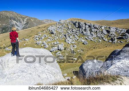 Stock Photo - Hiker standing on the Limestone outcrops of Castle Hill, South Island, New Zealand, Oceania. Fotosearch