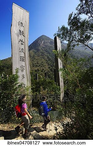 Stock Photo - Hikers in front of wooden stelae at Wisdom Path, Lantau Peak, Lantau Island, Hong Kong, China, Asia. Fotosearch