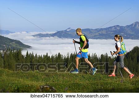 Stock Photography - Hikers in the mountains over cloud cover, Eggenalm, Reit im Winkl, Upper Bavaria, Bavaria, Germany, Europe. Fotosearch