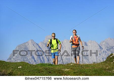 Stock Photograph - Hikers on the Eggenalm, behind Wilder Kaiser mountain range, Reit im Winkl, Upper Bavaria, Bavaria, Germany, Europe. Fotosearch