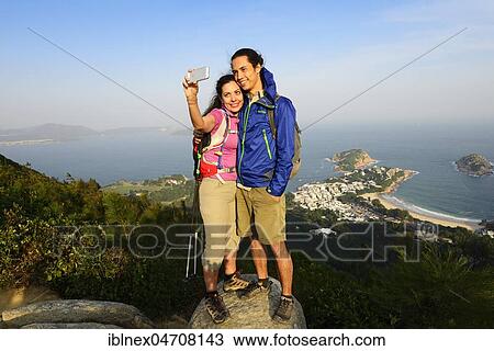 Hikers taking a selfie on a rock, Dragons Back Trail, view on Shek O Bay, Hong Kong, China, Asia View Large Photo Image Stock Image - Hikers taking a selfie on a rock, Dragons Back Trail, view on Shek O Bay, Hong Kong, China, Asia. Fotosearch