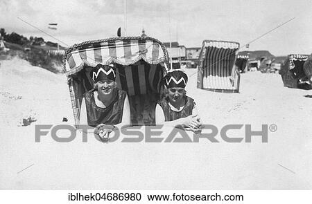 Holiday, two women lying on the beach in front of a beach chair, 1920s, Rügen, Baltic Sea, Germany, Europe View Large Photo Image Stock Image - Holiday, two women lying on the beach in front of a beach chair, 1920s, Rügen, Baltic Sea, Germany, Europe. Fotosearch