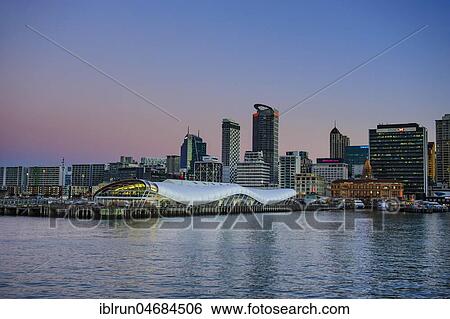 Stock Photograph - Illuminated waterfront with The Cloud during dusk, Queens Wharf, Auckland, New Zealand, Oceania. Fotosearch