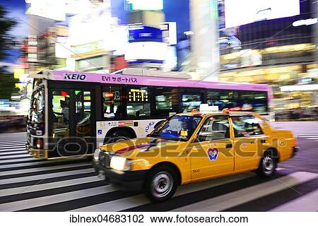 Stock Image - Infrastructure, traffic, yellow taxi and bus on Meiji Dori-Street, Shibuja Crossing, Tokyo, Japan, Asia. Fotosearch