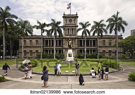 Stock Photograph - Korean and Japanese tourists taking photographs in front of the statue of first Hawaiian King Kamehameha I, 1758 - 1819, and the building of the Supreme Court, Honolulu, Hawai'i, USA, North America. Fotosearch