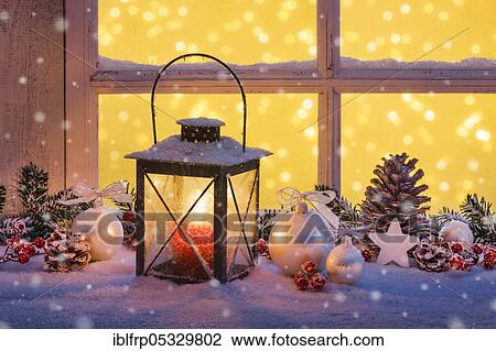Stock Image - Lantern with Christmas decoration on windowsill. Fotosearch