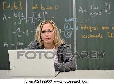 Stock Image - Laptop, trainee teacher, student, prospective teacher, young teacher, mathematics, blackboard, classroom, Baden-Wuerttemberg, Germany, Europe. Fotosearch