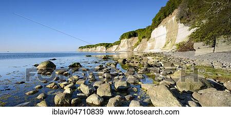 Stock Photo - Large stones on the shore of the Baltic Sea in front of the chalk cliffs of the cliffs, Jasmund National Park, Rügen Island, Mecklenburg-Western Pomerania, Germany, Europe. Fotosearch