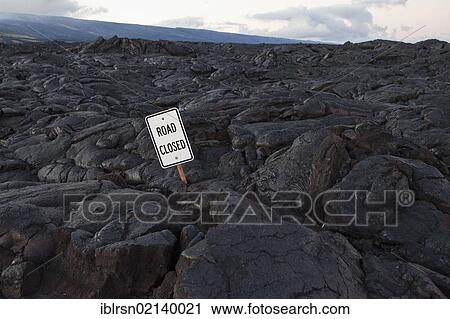 Stock Image - Lava field of pahoehoe type lava which has covered a road in Hawai'i Volcanoes National Park, Hawai'i, USA, North America. Fotosearch