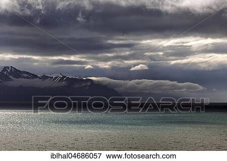 Stock Photo - Lighting atmosphere with dramatic clouds over the turquoise sea, Skjalandi fjord, near Husavik, North Iceland, Iceland, Europe. Fotosearch