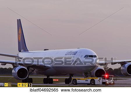 Lufthansa, Airbus, A340-600, with Push Back Truck, dusk, Munich Airport, Upper Bavaria, Bavaria, Germany, Europe View Large Photo Image Stock Photography - Lufthansa, Airbus, A340-600, with Push Back Truck, dusk, Munich Airport, Upper Bavaria, Bavaria, Germany, Europe. Fotosearch
