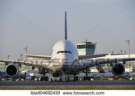 Lufthansa, Airbus, A380-800, with Push Back Truck towing from position to taxiway in front of satellite building (Terminal 2), evening mood, Munich Airport, Upper Bavaria, Bavaria, Germany, Europe View Large Photo Image Stock Photo - Lufthansa, Airbus, A380-800, with Push Back Truck towing from position to taxiway in front of satellite building (Terminal 2), evening mood, Munich Airport, Upper Bavaria, Bavaria, Germany, Europe. Fotosearch