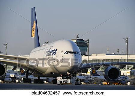 Lufthansa, Airbus, A380-800, with Push Back Truck towing from position to taxiway in front of satellite building (Terminal 2), evening mood, Munich Airport, Upper Bavaria, Bavaria, Germany, Europe View Large Photo Image Stock Photo - Lufthansa, Airbus, A380-800, with Push Back Truck towing from position to taxiway in front of satellite building (Terminal 2), evening mood, Munich Airport, Upper Bavaria, Bavaria, Germany, Europe. Fotosearch