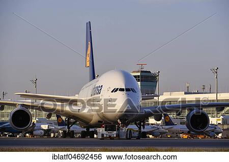 Stock Photograph - Lufthansa, Airbus, A380-800, with Push Back Truck towing from position to taxiway in front of satellite building (Terminal 2), evening mood, Munich Airport, Upper Bavaria, Bavaria, Germany, Europe. Fotosearch