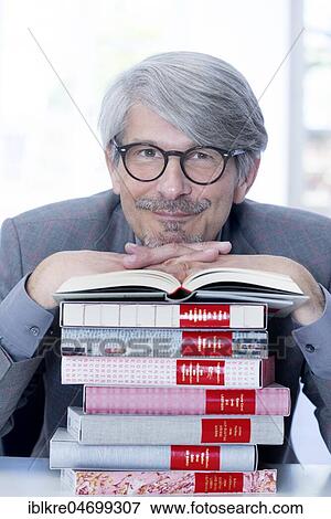 Stock Photo - Man leaning on a book pile. Fotosearch