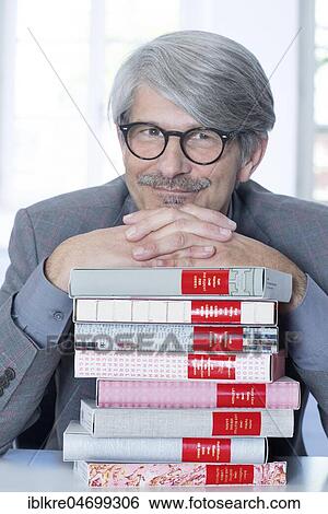 Man leaning on a book pile View Large Photo Image Stock Photograph - Man leaning on a book pile. Fotosearch