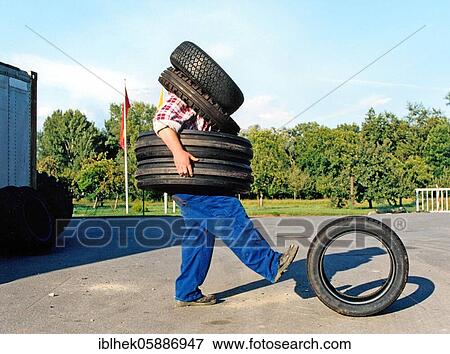 Stock Photo - Man wearing car tires, 2015, Germany, Europe. Fotosearch