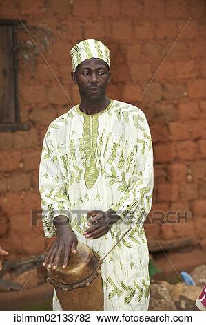 Man wearing traditional dress and playing a traditional musical instrument, Bamenda, Cameroon, Africa View Large Photo Image Stock Image - Man wearing traditional dress and playing a traditional musical instrument, Bamenda, Cameroon, Africa. Fotosearch