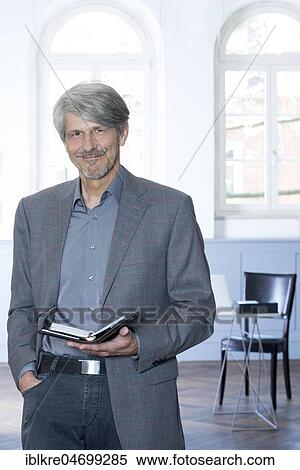 Stock Photography - Man with calendar in front of his office window. Fotosearch