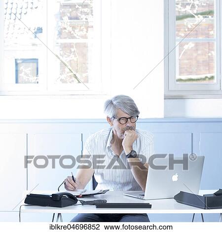Man working at the laptop in the office View Large Photo Image Stock Image - Man working at the laptop in the office. Fotosearch