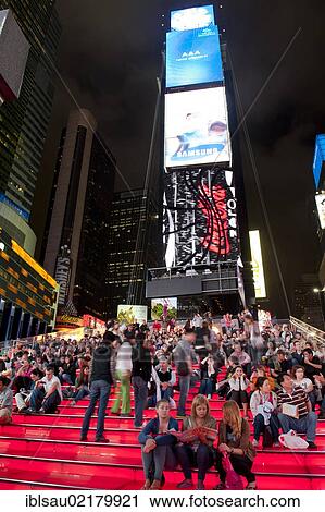 Stock Image - Many people on red stairs, TKTS, Broadway, Times Square pedestrian zone, Midtown, Manhattan, New York City, USA, North America. Fotosearch