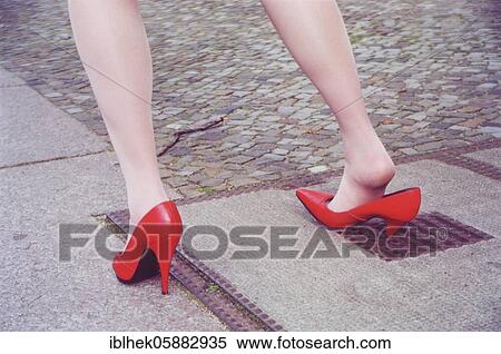 Stock Photography - Misfortune, woman gets stuck in a hole with high heels, Berlin, Germany, Europe. Fotosearch