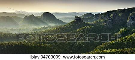 Stock Photo - Morning atmosphere in the Elbe Sandstone Mountains, view of Lorenzsteine and Hinteres Raubschloss or Winterstein, fog rises, Saxon Switzerland National Park, Saxony, Germany, Europe. Fotosearch