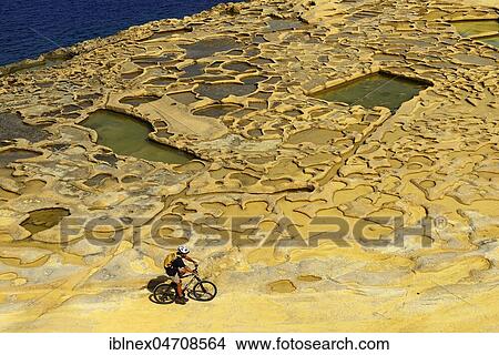 Picture - Mountain biking near Gozo salt pans, Xwejni Bay, Gozo Island, Malta, Europe. Fotosearch
