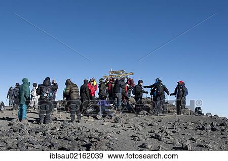 Mountaineering, mass tourism, many mountaineers at a sign on the summit of Mount Kilimanjaro, Kibo, Uhuru Peak, 5895m, Marangu Route, Tanzania, East Africa, Africa View Large Photo Image Stock Photo - Mountaineering, mass tourism, many mountaineers at a sign on the summit of Mount Kilimanjaro, Kibo, Uhuru Peak, 5895m, Marangu Route, Tanzania, East Africa, Africa. Fotosearch