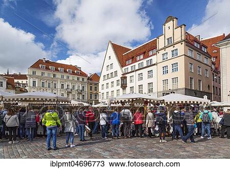 Stock Image - Old 18th century facades with terracotta roofs, market with tourists and souvenir vendors, Town Hall Square, Tallinn, Estonia, Europe. Fotosearch