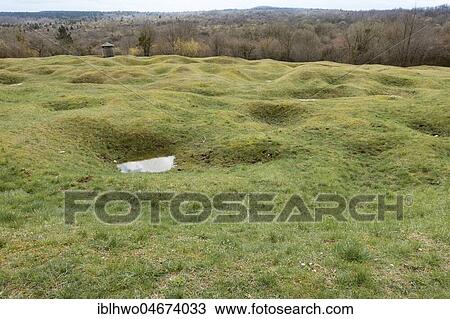 Stock Image - Open terrain with grenade funnels overgrown with grass, destroyed village Fleury-devant-Douaumont, First World War, Verdun, Grand Est, France, Europe. Fotosearch