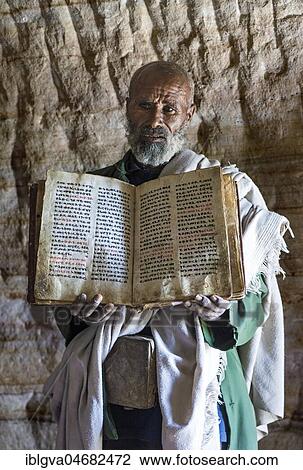 Orthodox priest of the rock church Mikael Mellehayzengi shows a book written by hand on parchment in the church language Ge'ez, Miracles of Mary, Mikael Mellehayzengi, Gheralta region, Tigray, Ethiopia, Africa View Large Photo Image Stock Image - Orthodox priest of the rock church Mikael Mellehayzengi shows a book written by hand on parchment in the church language Ge'ez, Miracles of Mary, Mikael Mellehayzengi, Gheralta region, Tigray, Ethiopia, Africa. Fotosearch