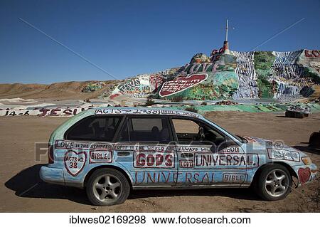 Stock Photo - Painted car in front of Salvation Mountain, a desert hillside covered with religious messages, created by Leonard Knight, Niland, California, USA, North America. Fotosearch
