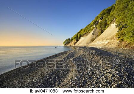 Stock Image - Pebble beach on the shore of the Baltic Sea in front of the chalk cliffs of the steep coast, Jasmund National Park, Rügen Island, Mecklenburg-Western Pomerania, Germany, Europe. Fotosearch