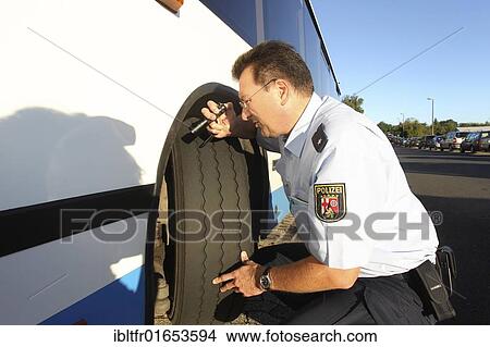 Police officer checking the tires of a school bus, Plaidt, Rhineland-Palatinate, Germany, Europe View Large Photo Image Picture - Police officer checking the tires of a school bus, Plaidt, Rhineland-Palatinate, Germany, Europe. Fotosearch