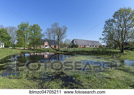 Stock Image - Pond, barn and horse stable of Gut Othenstorf, built in 1922, Mecklenburg-Western Pomerania, Germany, Europe. Fotosearch