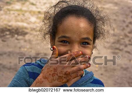 Portrait, smiling girl holding her hand decorated with henna patterns in front of her mouth, Skoura, Morocco, Africa View Large Photo Image Stock Photo - Portrait, smiling girl holding her hand decorated with henna patterns in front of her mouth, Skoura, Morocco, Africa. Fotosearch