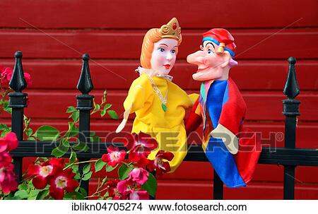 Picture - Punch puppets, Punch and Judy, princess, sitting on a metal fence. Fotosearch