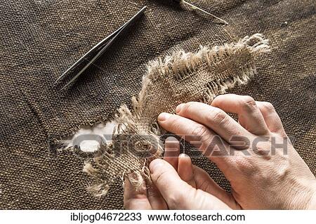 Restoration atelier, hands holding linen patch with thread bridges over crack in lent scarf, Munich, Bavaria, Germany, Europe View Large Photo Image Stock Image - Restoration atelier, hands holding linen patch with thread bridges over crack in lent scarf, Munich, Bavaria, Germany, Europe. Fotosearch