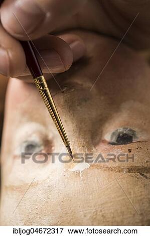 Stock Photo - Restoration studio, restorer, filling material is adapted to the angel's face with brush and paint, Munich, Bavaria, Germany, Europe. Fotosearch