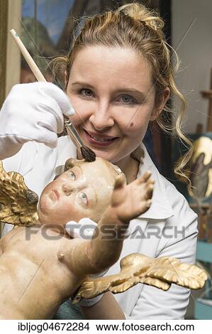 Restoration studio, restorer, woman cleans an angel with a brush, Munich, Bavaria, Germany, Europe View Large Photo Image Picture - Restoration studio, restorer, woman cleans an angel with a brush, Munich, Bavaria, Germany, Europe. Fotosearch