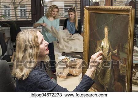 Restoration studio, restorer, woman cleans a painting with cotton swabs, in the back women work on supporting fabric for lent scarf in studio, Munich, Bavaria, Germany, Europe View Large Photo Image Stock Image - Restoration studio, restorer, woman cleans a painting with cotton swabs, in the back women work on supporting fabric for lent scarf in studio, Munich, Bavaria, Germany, Europe. Fotosearch