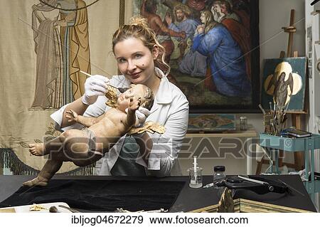 Restoration studio, restorer, woman cleans an angel with a brush, restored lent scarfs in the back, Munich, Bavaria, Germany, Europe View Large Photo Image Stock Photo - Restoration studio, restorer, woman cleans an angel with a brush, restored lent scarfs in the back, Munich, Bavaria, Germany, Europe. Fotosearch