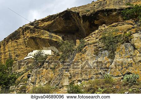 Stock Photograph - Rock with Orthodox rock church Petros and Paulos Melehayzengi, with wooden ladder as access, Tsaeda Amba Mountains, Tigray, Ethiopia, Africa. Fotosearch